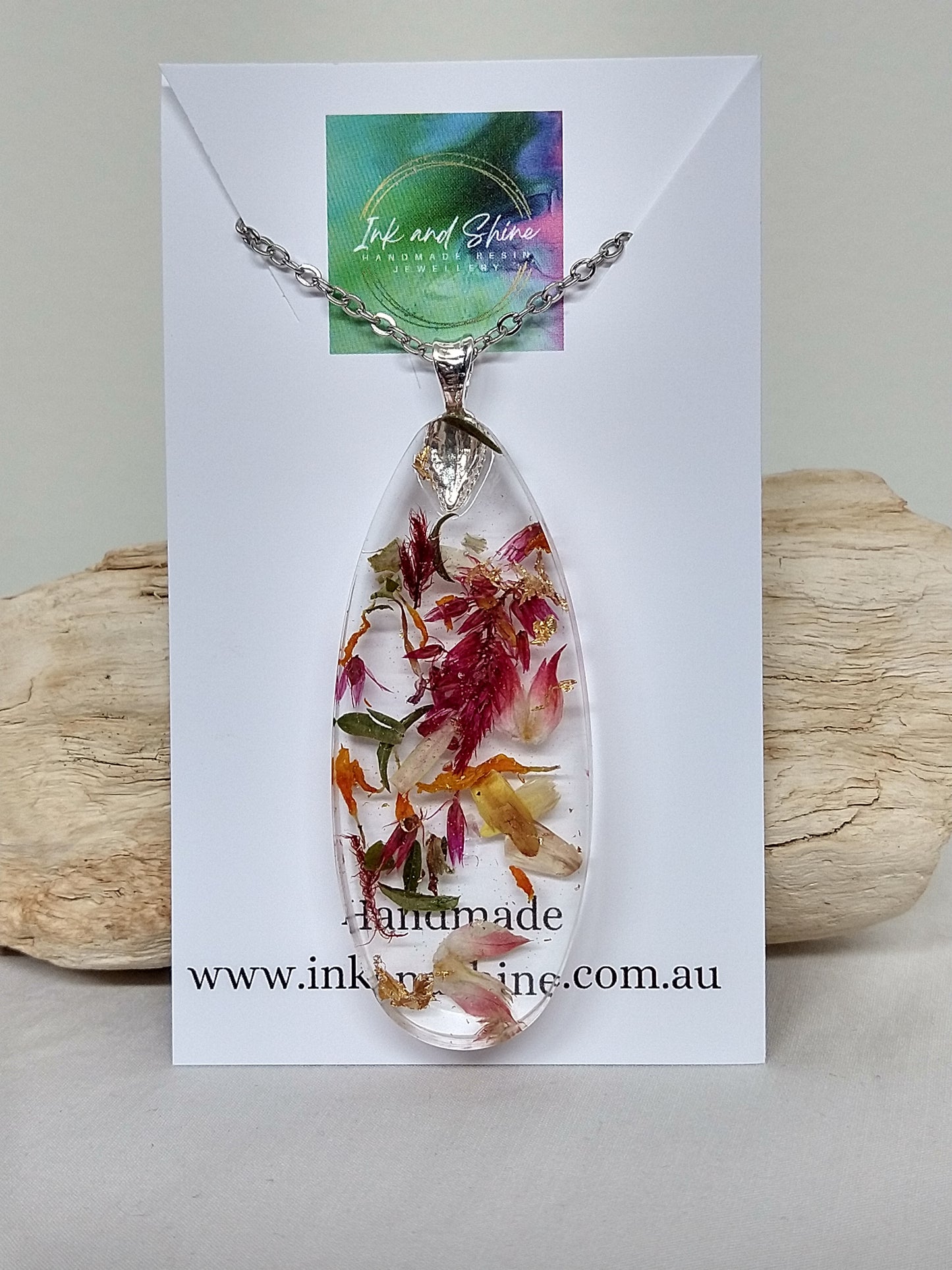 Ellipse shaped clear resin pendant necklace filled with organic dried flowers 